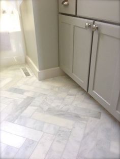 a white tile floor in a kitchen with gray cupboards and an instagram post