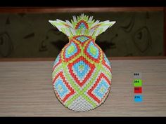 a colorful beaded pineapple sitting on top of a wooden table