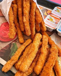 fried food items displayed on serving tray with tomatoes in background