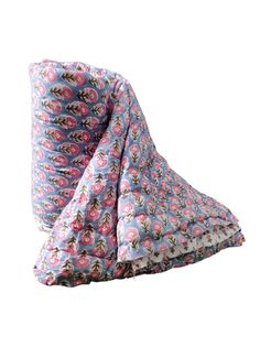 a blue and pink flowered blanket laying on top of a white surface