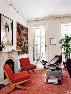 a living room filled with furniture and a fire place next to a painting on the wall