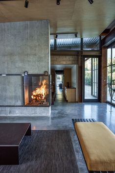 a living room with a fire place in the center and lots of windows on both sides