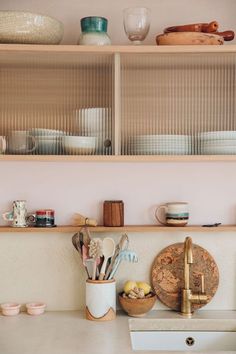 the kitchen counter is cluttered with dishes, cups and utensils on it