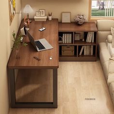 a laptop computer sitting on top of a wooden desk next to a white couch in a living room