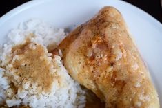 a white plate topped with rice and chicken