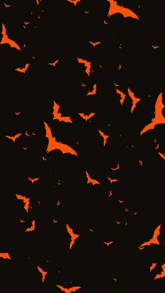 many bats flying in the night sky with orange glow on their wings and black background