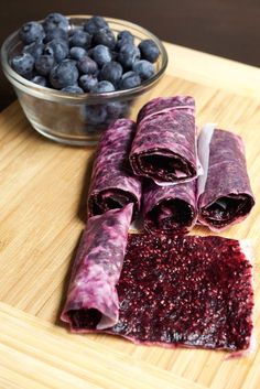 blueberries and cranberry wrap on a cutting board next to a bowl of berries