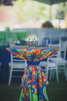 the table is decorated with colorful cloths and a glass ball on it's top