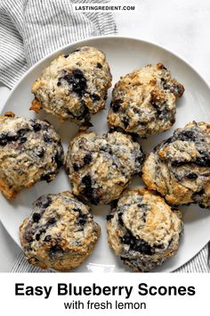 blueberry scones with fresh lemon on a white plate and text overlay reads easy blueberry scones with fresh lemon