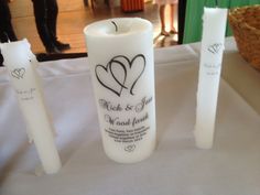 three candles are sitting on a table with two hearts and the words, wedding favors