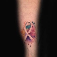 a watercolor tattoo with a pink ribbon on the left arm and an abstract design