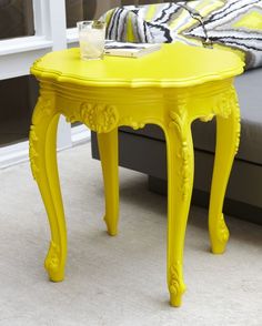 a yellow table sitting in front of a couch