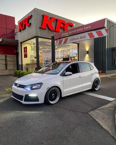 a white car parked in front of a kfc store