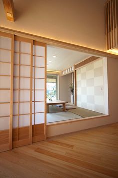 an empty room with wood flooring and white wall covering the walls, in front of a sliding glass door