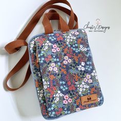 a small floral purse with a brown strap