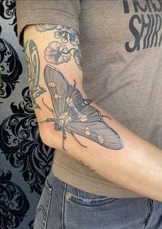 a person with a butterfly tattoo on their arm