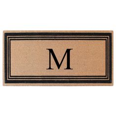 a door mat with the letter m in black and tan on it, against a white background