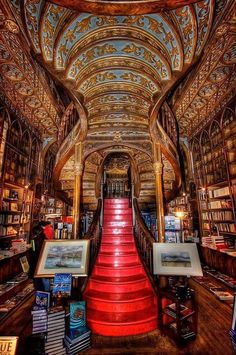 an ornately decorated library with red stairs and bookshelves