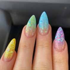 a woman's hand with some colorful nail polishes on her fingers and two different colors