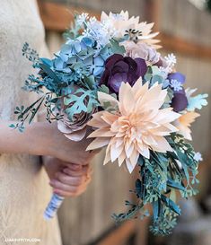 a woman holding a bouquet of flowers in her hand with blue and pink colors on it