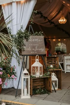 a sign that says welcome to the guests at a wedding reception with candles and flowers