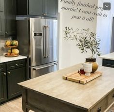 a kitchen with an island in the middle and stainless steel appliances on the other side