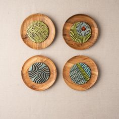 three wooden plates with designs on them