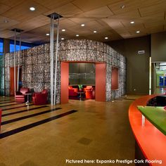 an empty room with chairs and tables in front of a wall made out of rocks