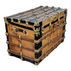 an old trunk sitting on top of a hard wood floor next to a white wall