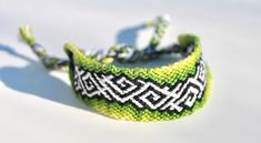 a close up of a bracelet on a white surface with a green and black design