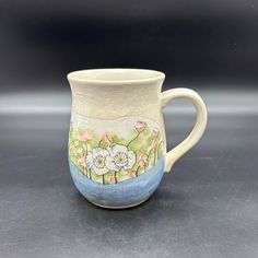 a ceramic mug with flowers painted on it