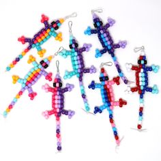 four pairs of cross beaded earrings on white background with clippings attached to them