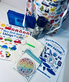 an assortment of children's books and toys on a white table with blue bags