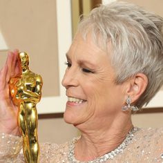 an older woman holding up her oscar statue