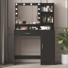 a black vanity with lights on it next to a potted plant