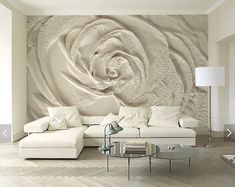 a living room with white furniture and a large wall mural