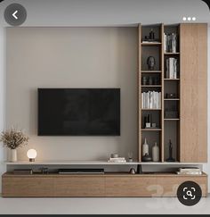 a flat screen tv mounted to the side of a wall next to a book shelf