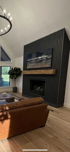 a living room with couches and a fireplace in the corner, next to a large window