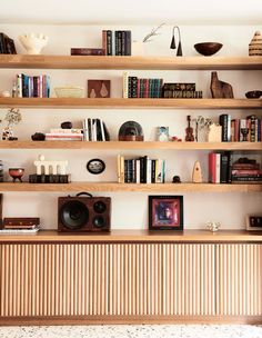 a bookshelf filled with lots of books on top of wooden shelves