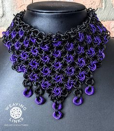 a black and purple chainmail necklace on a mannequin neckpiece with circular links