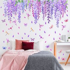 a bedroom with purple flowers on the wall and butterflies hanging from it's ceiling