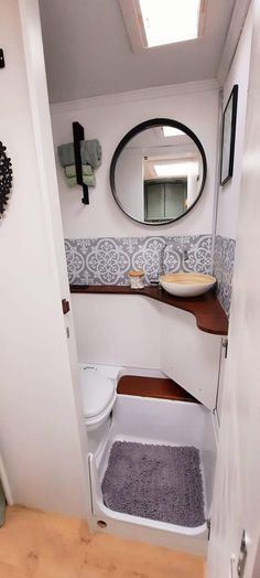 a bathroom with a sink, mirror and toilet in it's corner area on the floor