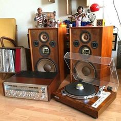 an old record player sitting on top of a wooden table next to other musical equipment