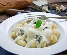 a white plate topped with ravioli and cheese