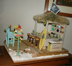 there is a miniature surfboard and chairs on the table