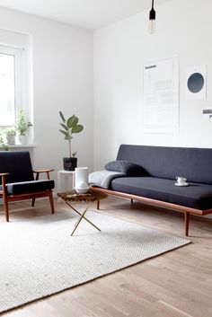 a living room with white walls and wooden floors