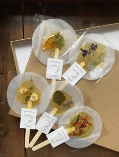 four plates with different types of food on them sitting on top of a wooden table