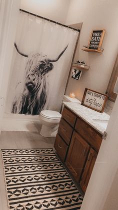 a bathroom with a black and white cow shower curtain in it's stall area