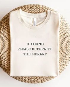 a white t - shirt that says if found please return to the library on it