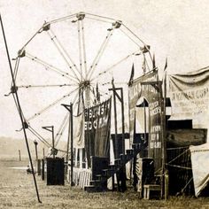 an old black and white photo of a ferris wheel in the middle of a field